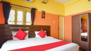 a bedroom with a bed with red and white pillows at Couple Friendly Rooms in kolkata