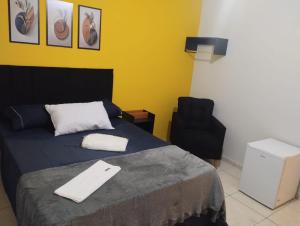 イタチバにあるBee Hotel Itatibaのベッドルーム1室(ベッド1台、黒い椅子付)