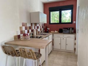 a kitchen with a wooden table and two chairs at Les Gîtes W''elles''come in Cotignac +5 photos