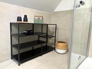 a black shelf in a bathroom with a shower at Fewo Wolke in Menslage +22 photos
