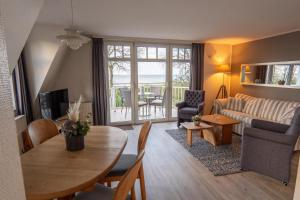 a living room with a table and a living room with a couch at Strandvilla Drei Mäderl Haus in Boltenhagen