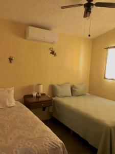 a hotel room with two beds and a window at Coco Cabanas Loreto in Loreto
