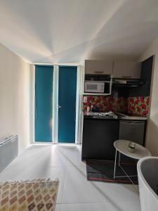 Η κουζίνα ή μικρή κουζίνα στο STUDETTE LA ROSÉE ABONDANTE Non-fumeur, 45 min de Paris, 10m2, indépendante, cosy, apaisante, mobiliers convertible, WiFi, TV, kitchenette, sanitaires inclus visibles dans la même pièce, mini terrasse, jardin, canapé-lit 120x180, 1 à 2 pers gabarit moyen