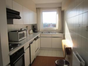 a small kitchen with a microwave and a window at Zoutezoute in Knokke-Heist +35 photos