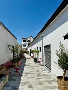 a patio with red chairs and tables and a building at Markt 15 in Weiden am See