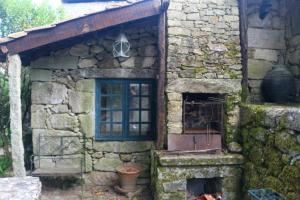 a stone house with a window and a fireplace at Casa da Tia Augusta in Castro Daire