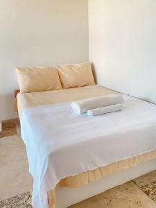 a white bed with a towel on top of it at Suítes Pé Nareia Itaipuaçu in Maricá +17 photos