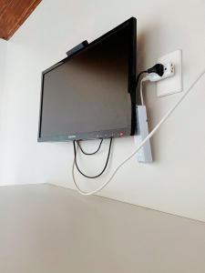 a flat screen tv hanging on a wall at Suítes Pé Nareia Itaipuaçu in Maricá