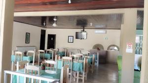 a dining room with tables and chairs and a television at Hotel Vale Das Serras in Jacobina