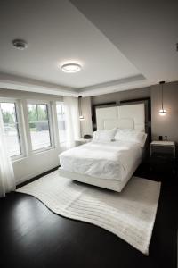 a bedroom with a large white bed and a rug at the reid hotel in Vanderhoof