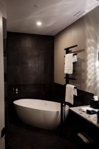 a bath tub in a bathroom with a black wall at the reid hotel in Vanderhoof