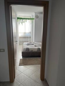 a bedroom with a bed and a window and a mirror at Resa Apartment in Vlorë