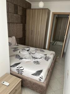 a bedroom with a bed with a black and white comforter at Resa Apartment in Vlorë +57 photos