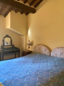 a bedroom with a blue bed and a mirror at Appartamento Puliesini in Montieri
