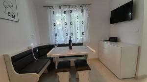 a small room with a table and a couch and a tv at Apartments MajaPaula in Slatine