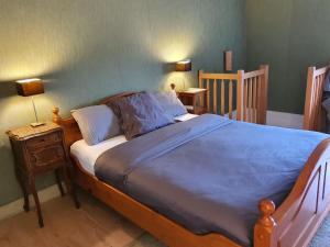 a bedroom with a large bed with a blue blanket at Irie Vibes in Bourganeuf