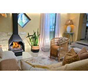 a living room with a couch and a fireplace at SAGE Cottage Bloubergstrand in Cape Town +19 photos