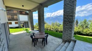 a table and chairs on a patio with a view of mountains at A casa di Martina - CIR 0051 in Aosta