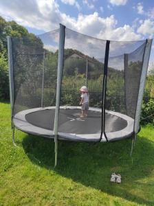 a little girl is playing on a trampoline at DM DOMKI Kościelna 54 in Mielno