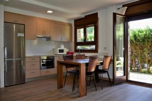 a kitchen with a wooden table and chairs in it at Apartament Cal Cinto in Sort