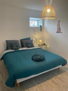 a bedroom with a bed with a large blue comforter at Jungle appartement lumineux plein centre in Boulogne-sur-Mer