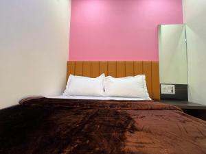 a bed in a room with a pink wall at Parel Residency in Mumbai +20 photos