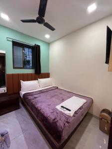 a bedroom with a bed with a purple blanket at Parel Residency in Mumbai