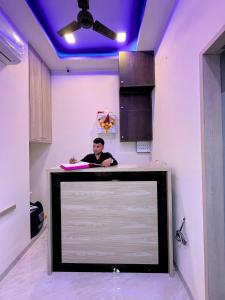 a man sitting at a desk in a room with a tv at Parel Residency in Mumbai