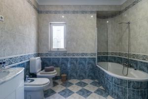 a bathroom with a toilet and a tub and a sink at Quinta da Falfeira in Lagos +47 photos