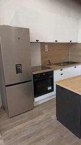 a kitchen with a refrigerator and a stove top oven at Large 40m2 Prox Lille-métro-tram in Roubaix +6 photos