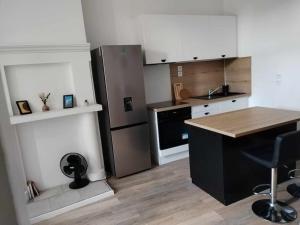 a kitchen with a refrigerator and a table in it at Large 40m2 Prox Lille-métro-tram in Roubaix