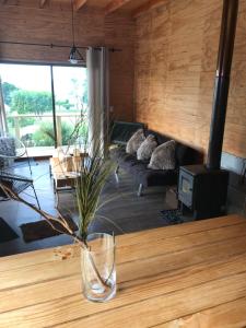 a living room with a vase on a wooden table at Vistaranco in Lago Ranco