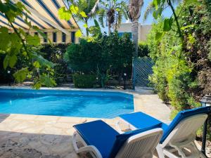 a pool with two chairs and a table and a swimming pool at Polis Beach Villa in Prodhromi