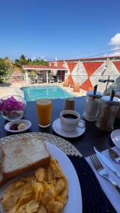 a table with a plate of breakfast food and a pool at Hotel La Mar Playas in Playas