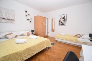 twee bedden in een kamer met witte muren en houten vloeren bij Guest house Damir in Ražanac