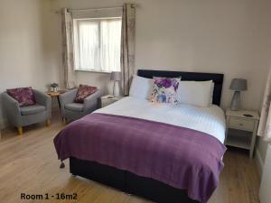a bedroom with a bed and a chair and a window at Lakeside Loughrea in Loughrea