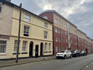 a row of buildings on a street with parked cars at Birmingham City Stay Apartments in Birmingham
