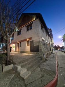 een wit gebouw met een deur in een straat bij Casa Laura Bariloche in Bariloche