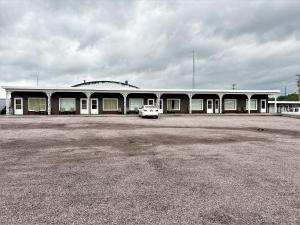 a building with a car parked in a parking lot at Siesta Motel in Mitchell