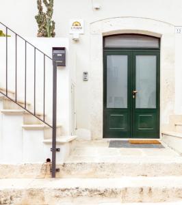 a green door on a white building with stairs at AI PALMENTI B&B in Adelfia