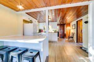 a kitchen with white cabinets and a counter with stools at Houghton Lake Cottage - Central Location! in Houghton Lake +22 photos