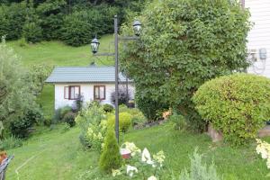 a garden with a light pole and a small house at Котедж "Красний Краєвид" in Yaremche