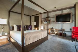 a bedroom with a canopy bed and a red chair at Fairmont Chicago Millennium Park in Chicago +37 photos