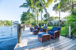 a row of chairs on a dock next to the water at The Riverside Retreat 2 in Fort Lauderdale
