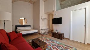 a living room with a red couch and a bed at ION Luxury Home in Polignano a Mare