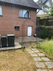 a house with two trash cans in the yard at Ferienhaus fussläufig vom Biggesee in Attendorn