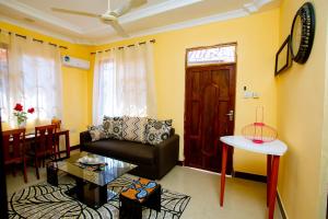 a living room with a couch and a table at Vee Sweet Villa in Dar es Salaam
