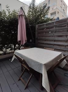 a table and an umbrella sitting on a patio at Le Romainvillois-Terrasse aux portes de Paris in Romainville