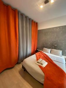 a bedroom with a bed with an orange curtain at Le Romainvillois-Terrasse aux portes de Paris in Romainville