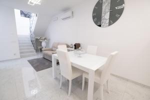 a white dining room with a white table and chairs at MirabiLuxury in Borgo Fosso Ghiaia +21 photos